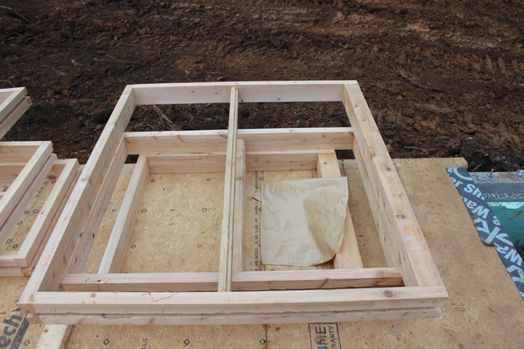 Door and window bucks are custom frames that will be built into the log wall.  There's a 3/4" channel in middle of the buck where a cedar spline will be driven to ensure no air or water penetration.  When the doors & windows arrive, you just nail them in place.