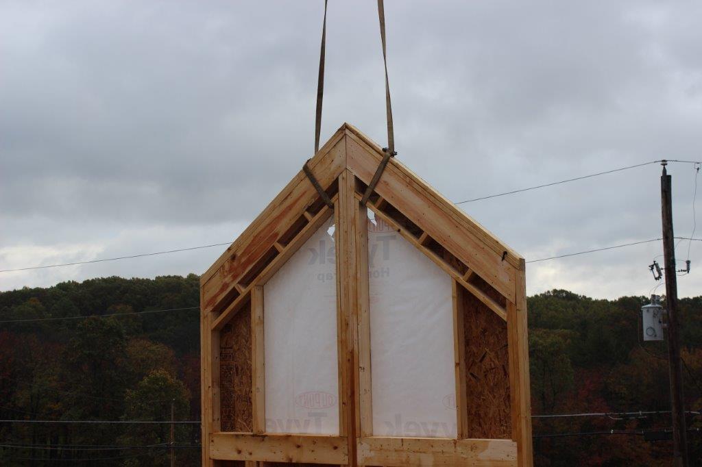 The Lakeview has a lot of glass on the bumpout, so we frame it and side it using log siding.  Here, the top of the gable wall is lifted into place.