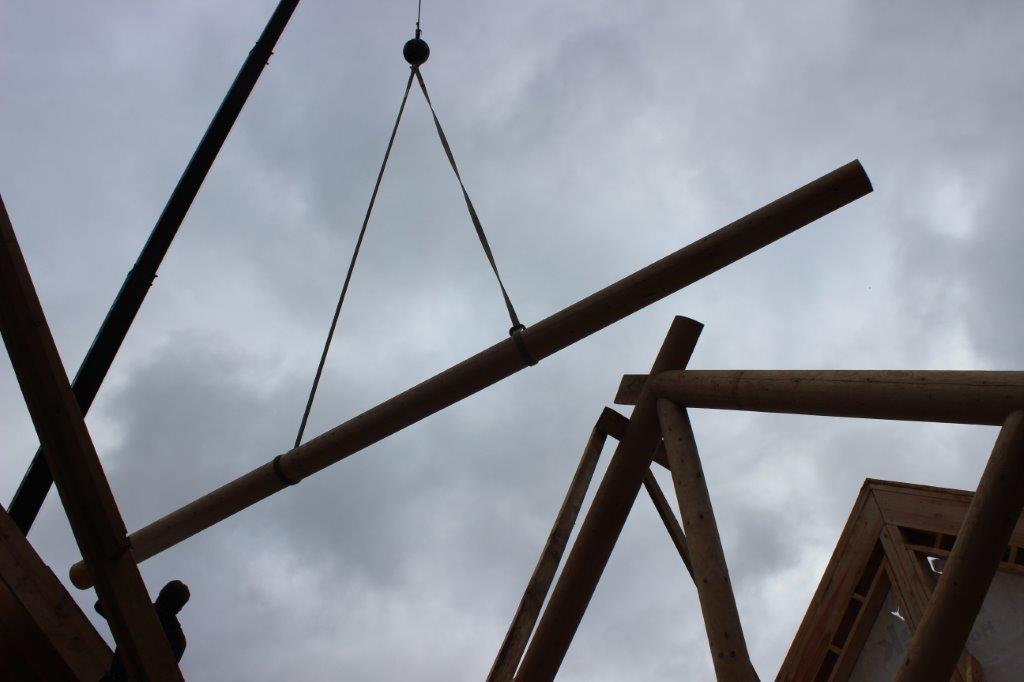 Spruce purlins get pretty heavy, so a crane is typically used to install them as the crew fastens them into place.
