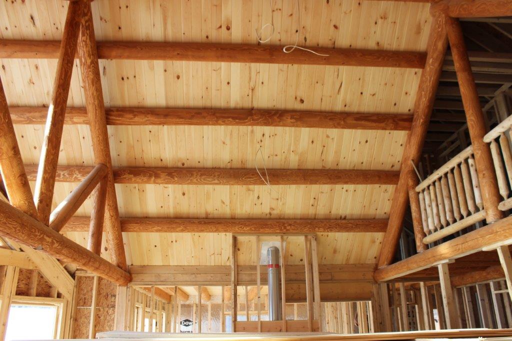 The purlin roof is covered by tongue and groove pine, and supported by trusses.  You can see the chimney chase bottom center.