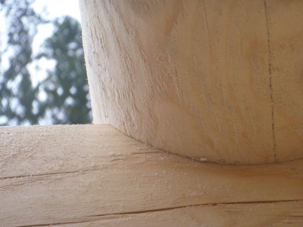 A close-up of how a log has been scribed and cut so that a floor joist can fit snugly on top.